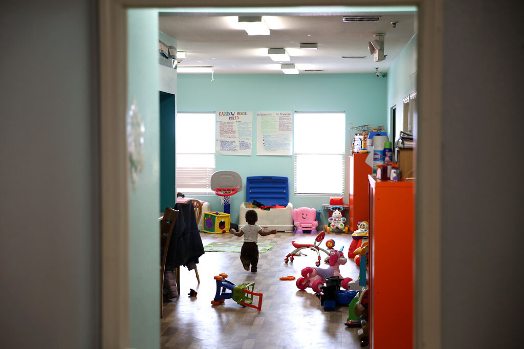 A child staying at Rainbow House runs through the shelter's play room